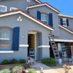 Gray two-story Sacramento home with blue shutters during professional exterior painting