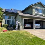 Professional painter working on a green Sacramento home with crisp white exterior trim