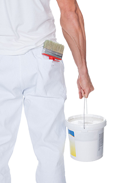 Painter carrying a bucket of paint