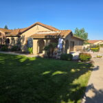 Completed beige exterior house painting project with stone accents