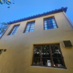 Freshly painted beige stucco exterior with dark window trim