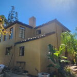 Beige stucco home exterior with freshly painted walls and dark trim