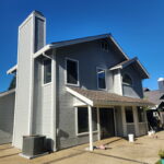 Modern two-story home exterior painted charcoal gray with crisp white trim