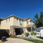 Freshly painted cream two-story home with white trim and stone accents
