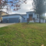 Freshly painted gray two-story house with white garage doors in Sacramento
