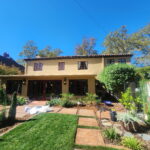 Painter preparing the exterior of a tan Sacramento home for a new paint job